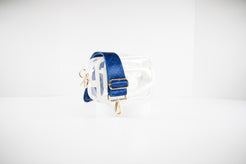 Clear stadium bag shown in white leather trim with a crossbody strap in red, white and blue team colors of the Chicago Cubs.