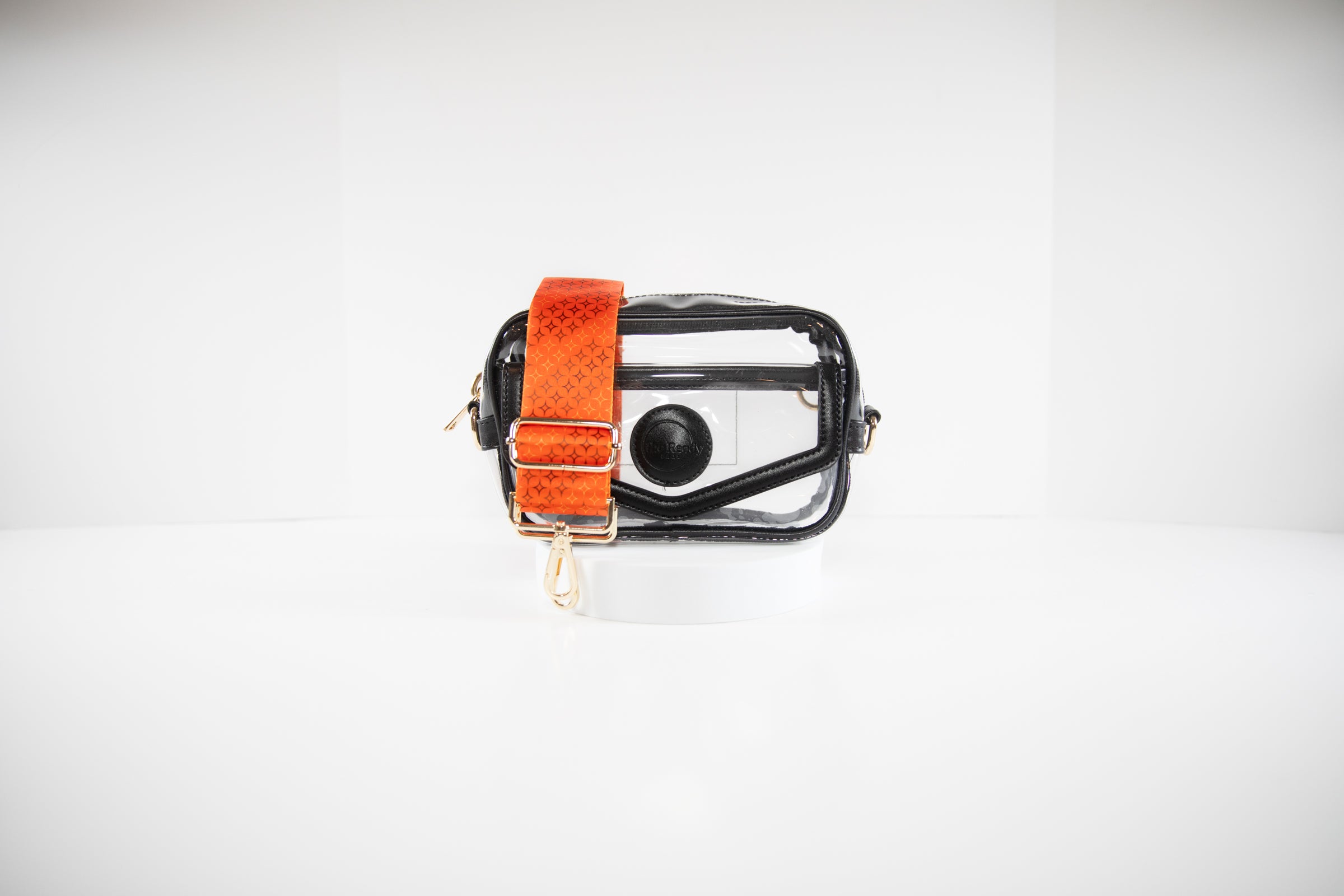 Clear stadium bag with black leather trim shown with a crossbody strap in team colors of the San Francisco Giants.