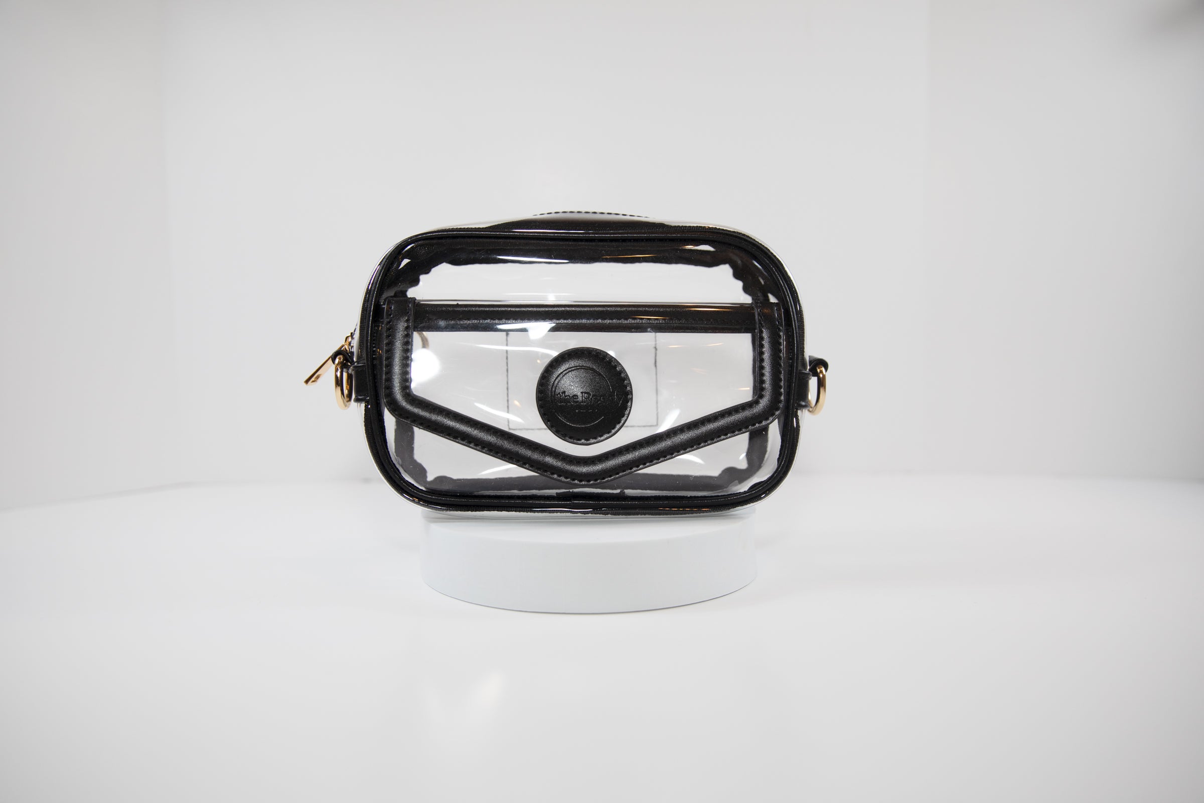 Clear stadium bag with gold hardware, front facing, that can be worn as a crossbody or a belt bag.