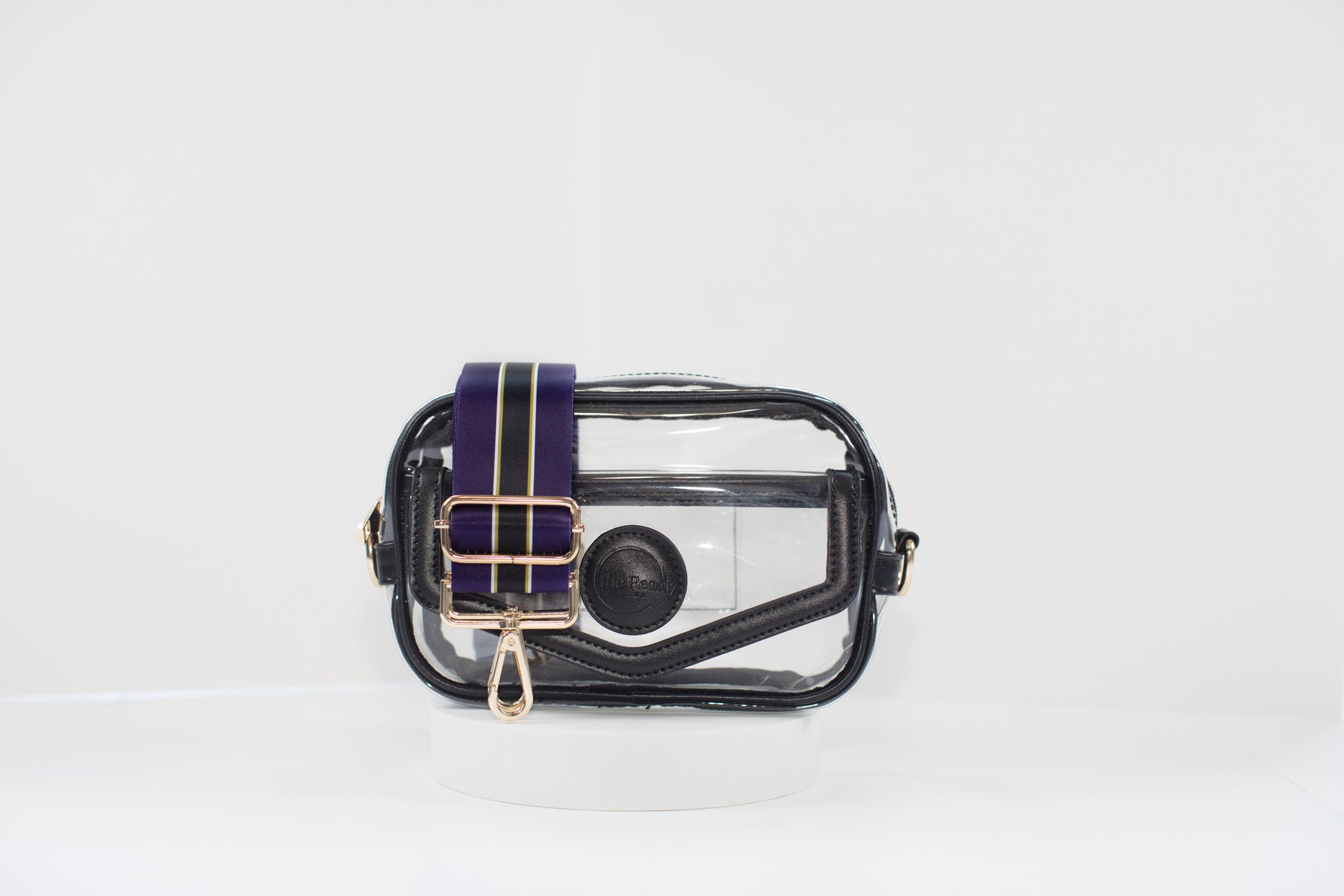 Clear stadium bag with black leather trim, front facing, with a crossbody strap in team colors of the Baltimore Ravens.
