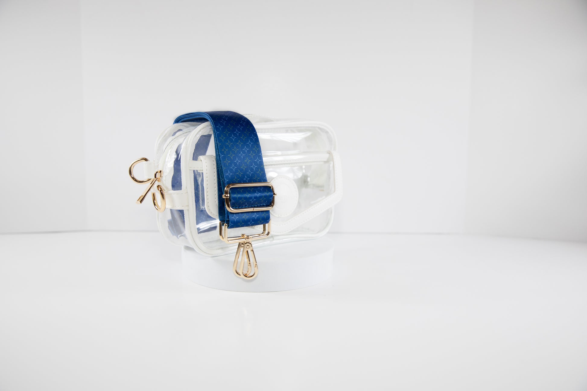 Clear stadium bag with white leather trim shown with a crossbody strap in Kansas City Royals team colors of navy and gold.