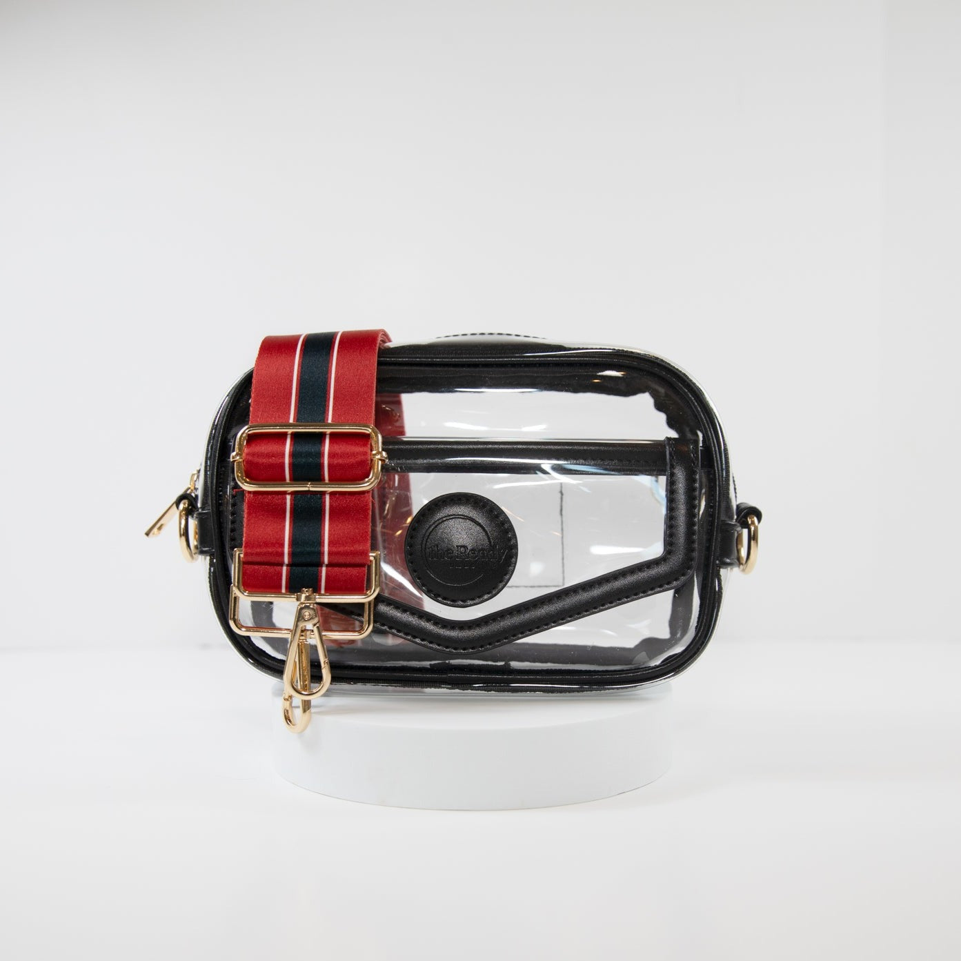 Clear stadium bag with black leather trim, front facing, with a crossbody strap in Houston Texan team colors.