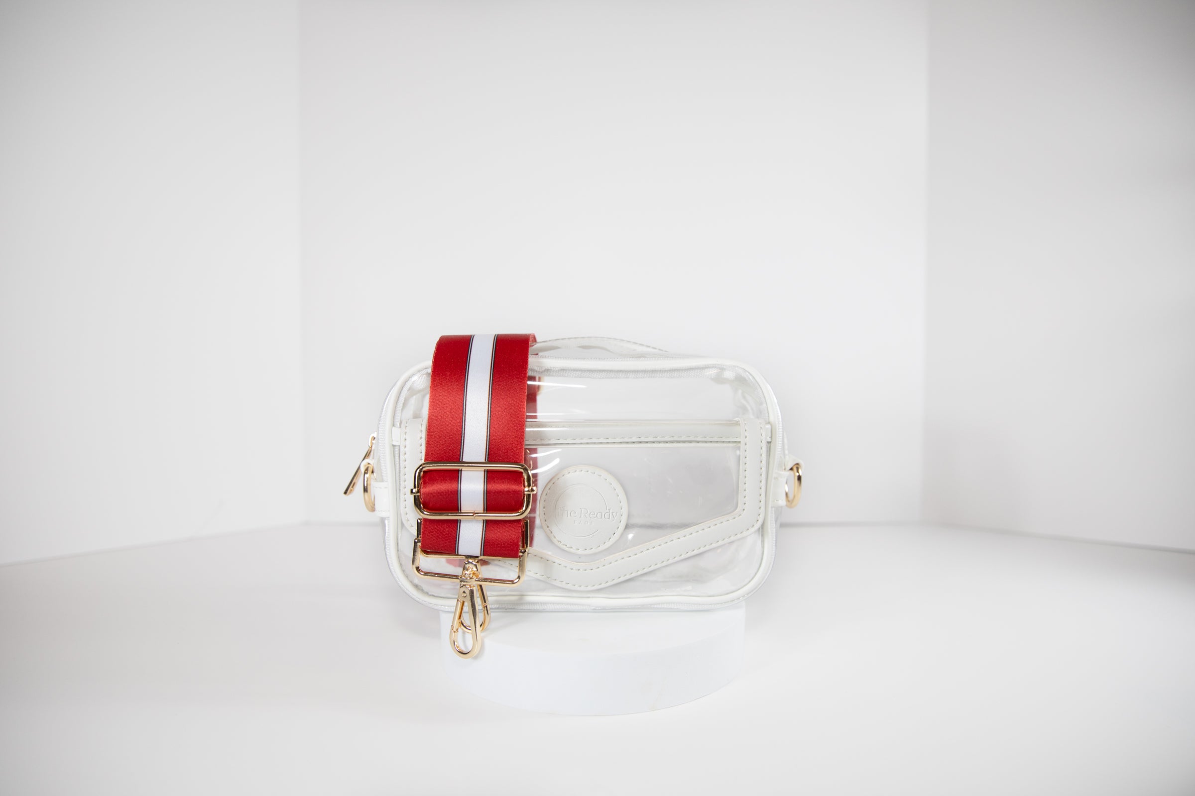 Clear stadium bag in white leather trim, front facing, with a crossbody strap in Wisconsin Badger colors.