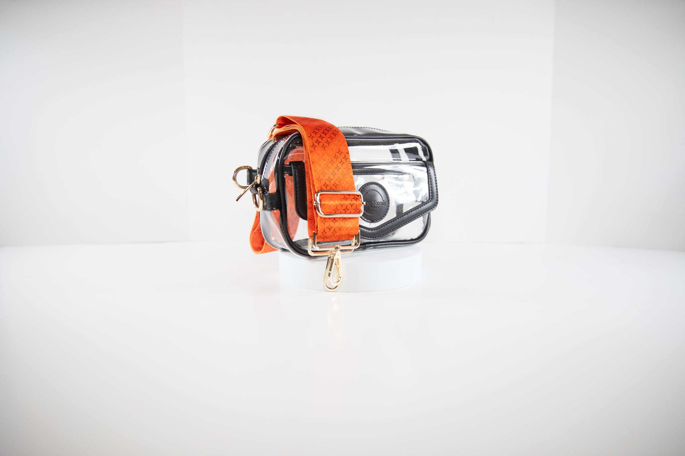 Clear stadium bag with black leather trim shown with a crossbody strap in team colors of the San Francisco Giants.