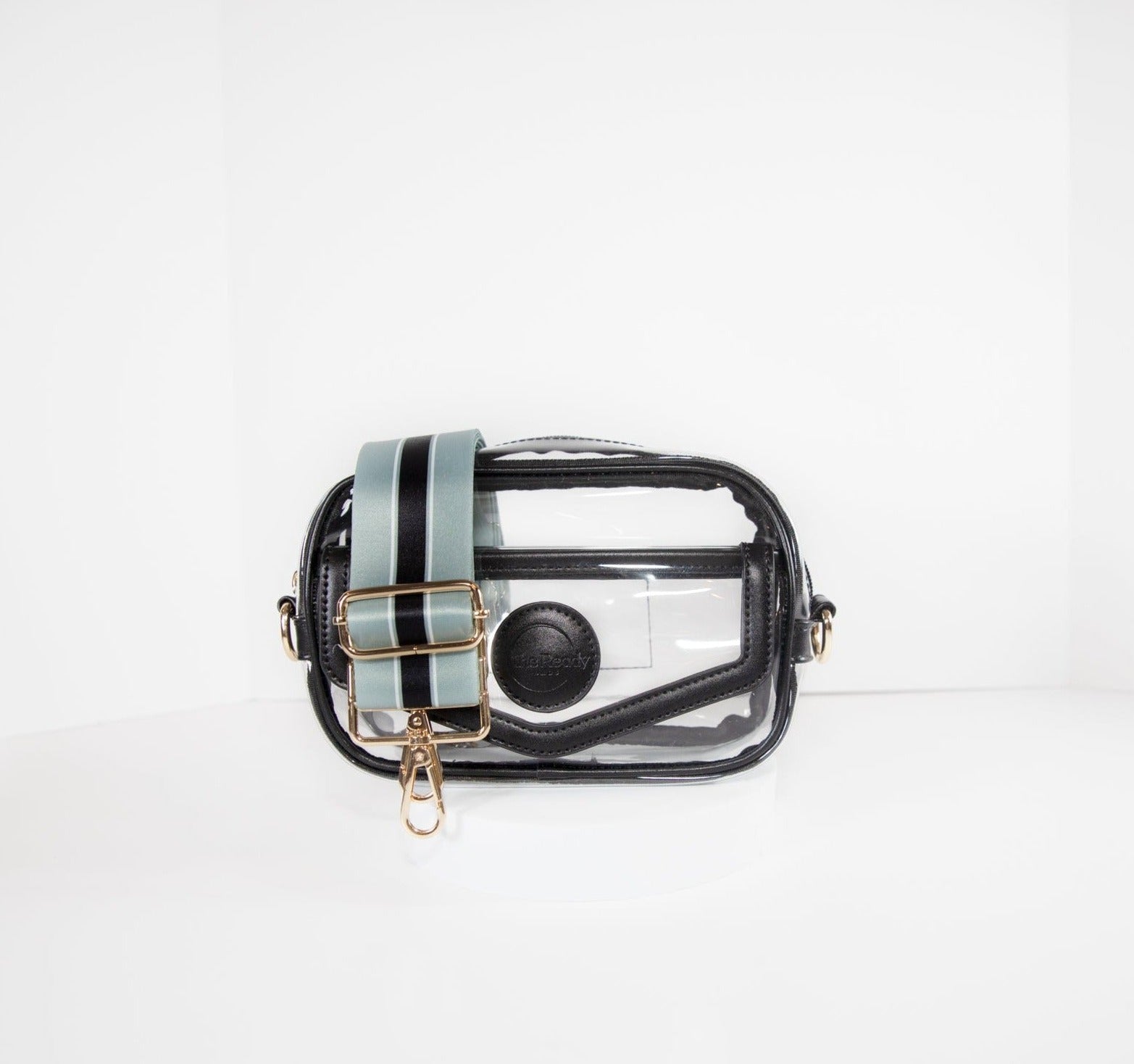 Clear stadium bag with black leather trim, front facing, with a crossbody strap in the Las Vegas Raiders Silver and Black team colors.