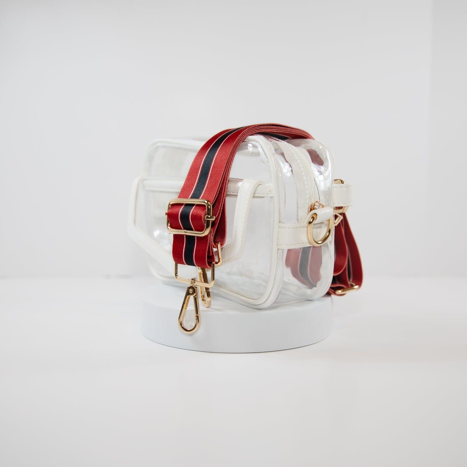 Clear stadium bag with white leather trim, side facing, with a crossbody strap in Houston Texan team colors.