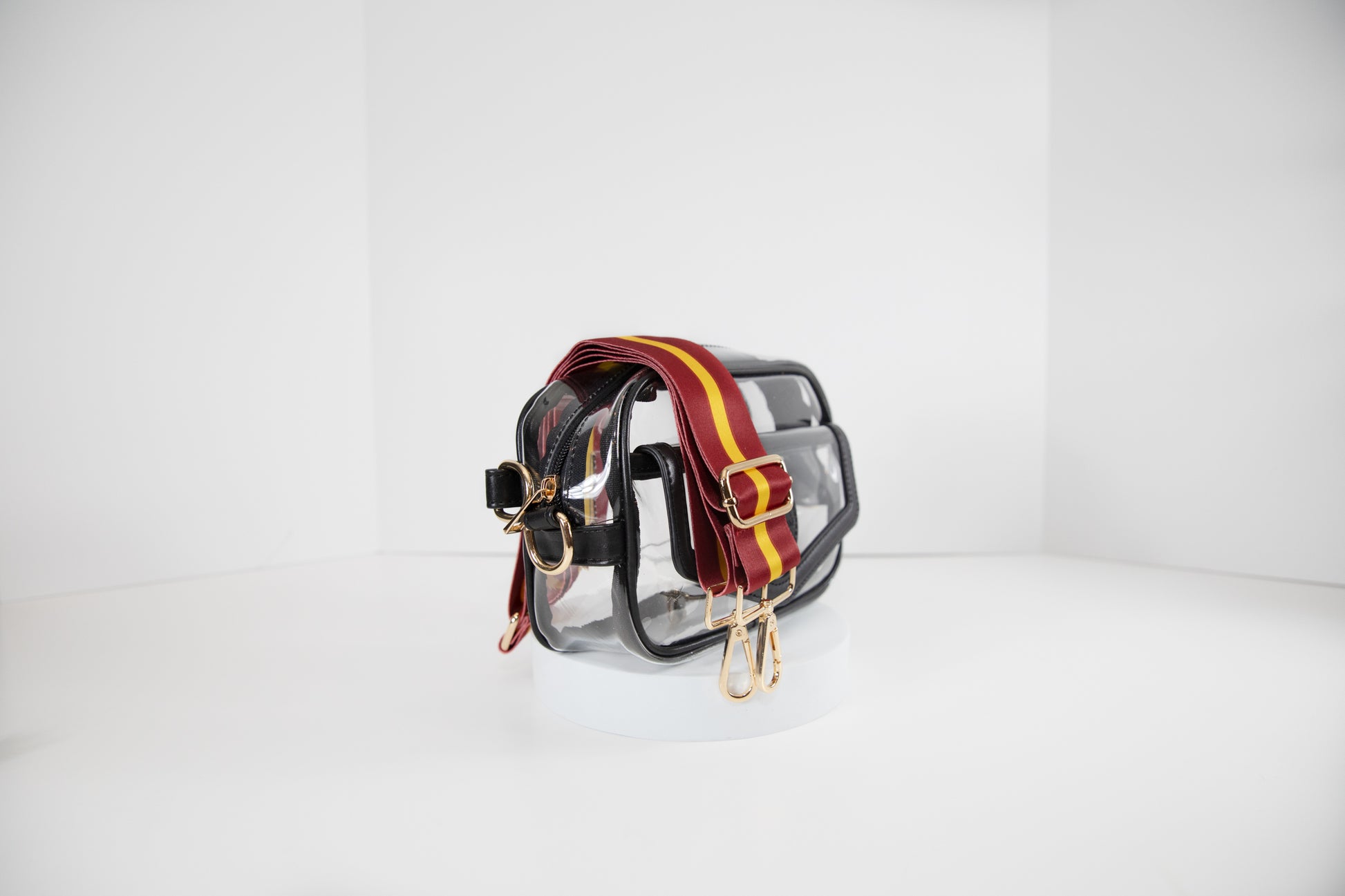 Clear stadium bag in black leather trim, side facing, with a crossbody strap in USC Trojan team colors.